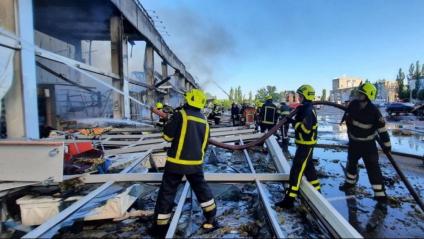 Bombers i membres dels equips de rescat, extingint ahir l’incendi causat pels atacs russos en un centre comercial a Krementxuk