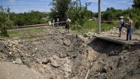 Diverses persones observen el forat causat per un bombardeig rus, a Khàrkiv