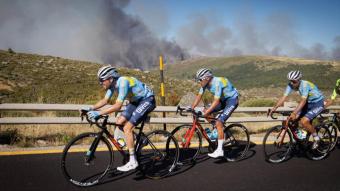 Ciclistes que participen al Tour de Portugal disputen una etapa amb el fum de l’incendi de la Serra da Estrela al fons