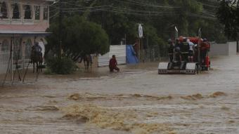 Equips de rescat patrullen sobre un camió per un carrer totalment inundat a Toa Baja