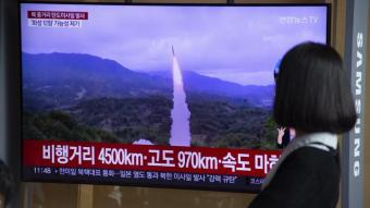 Una dona observa en una televisió a Seúl el llançament del míssil nord-coreà