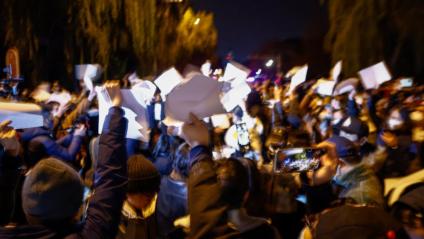 Manifestants sostenen folis en blanc, en una protesta pacífica a Pequín, diumenge