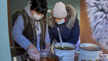 Treballadores municipals preparen menjar en un dels punts de suport equipat amb corrent elèctric a Khàrkiv