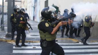Un policia dispara un projectil de fum contra els manifestants a Lima
