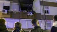 Quatre persones miren la finestra del pis sinistrat, destrossada pel foc