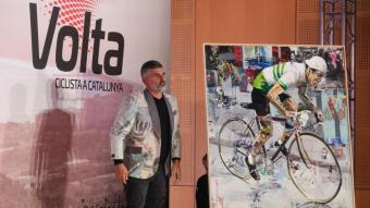 Miguel Soro, artista i exciclista de Xàtiva, mostra el cartell de la 102a Volta