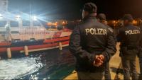 Agents de policia esperen l’arribada del vaixell amb els cossos dels vuit migrants morts, avui a Lampedusa
