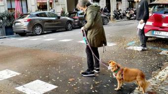 Una dona passeja amb el seu gos per Barcelona