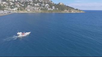 Una barca surt del port de Roses, en una instantània presa amb un dron
