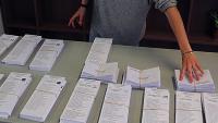 Paperetes i sobres a punt en una mesa electoral a Girona