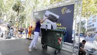 La presidenta de l’ANC, Dolors Feliu, posant una foto de Felip VI en un contenidor
