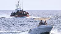 Un vaixell de la Guàrdia Costanera italiana a l’arribada del port de Lampedusa, amb un grup de persones salvades a bord